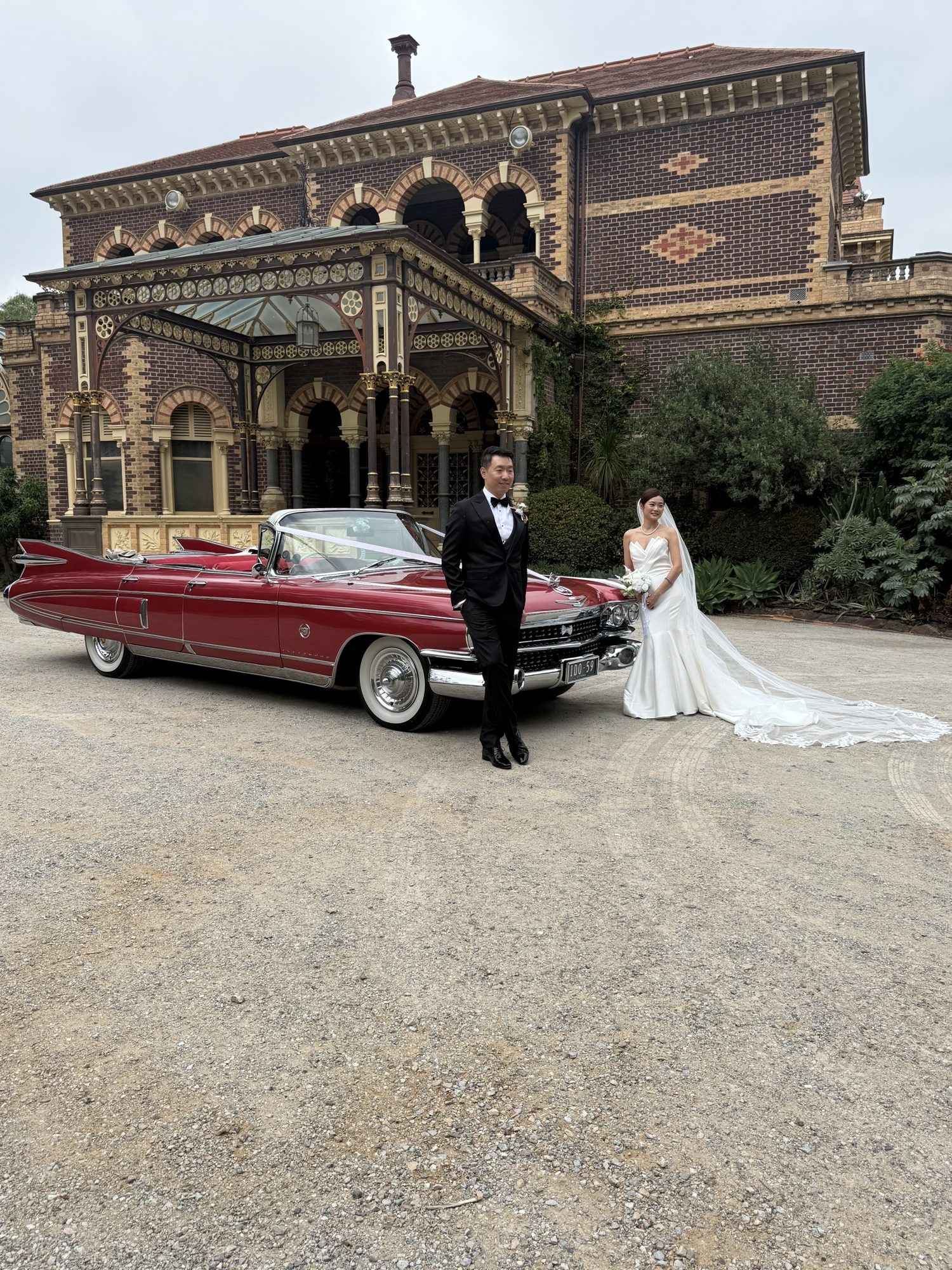 Rosie, Caddyman's rose pink Cadillac convertible wedding car, outside a heritage mansion