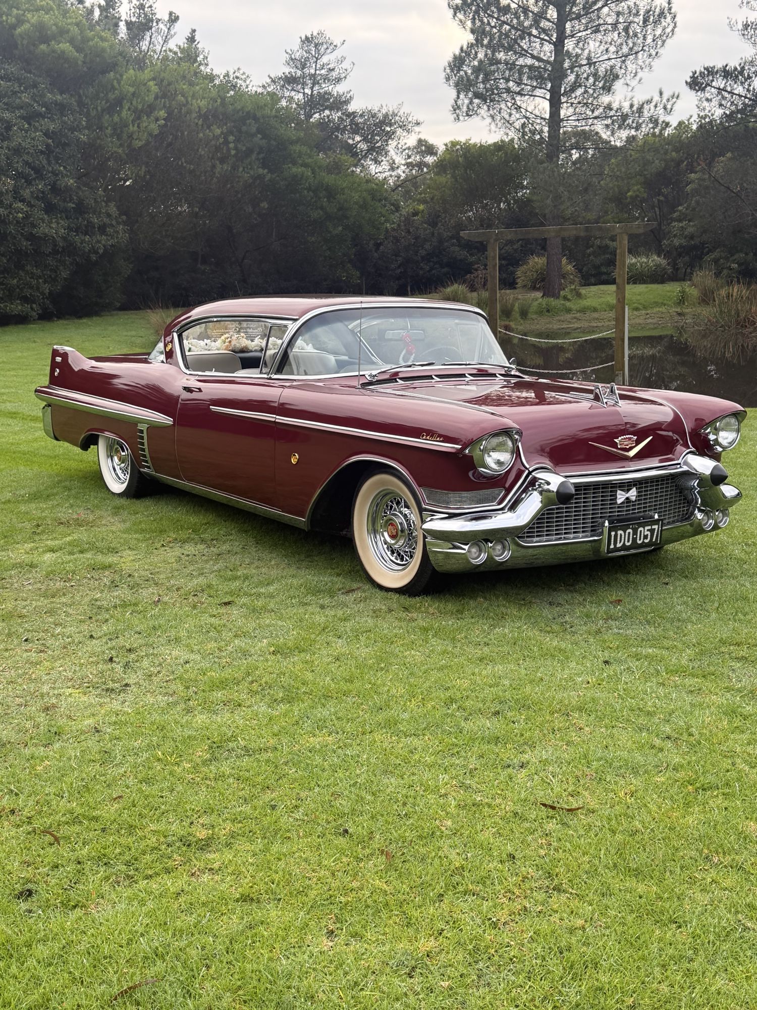 ELLIE Mae, Caddyman's maroon classic Cadillac coupe, parked on a lawn, front three-quarter view