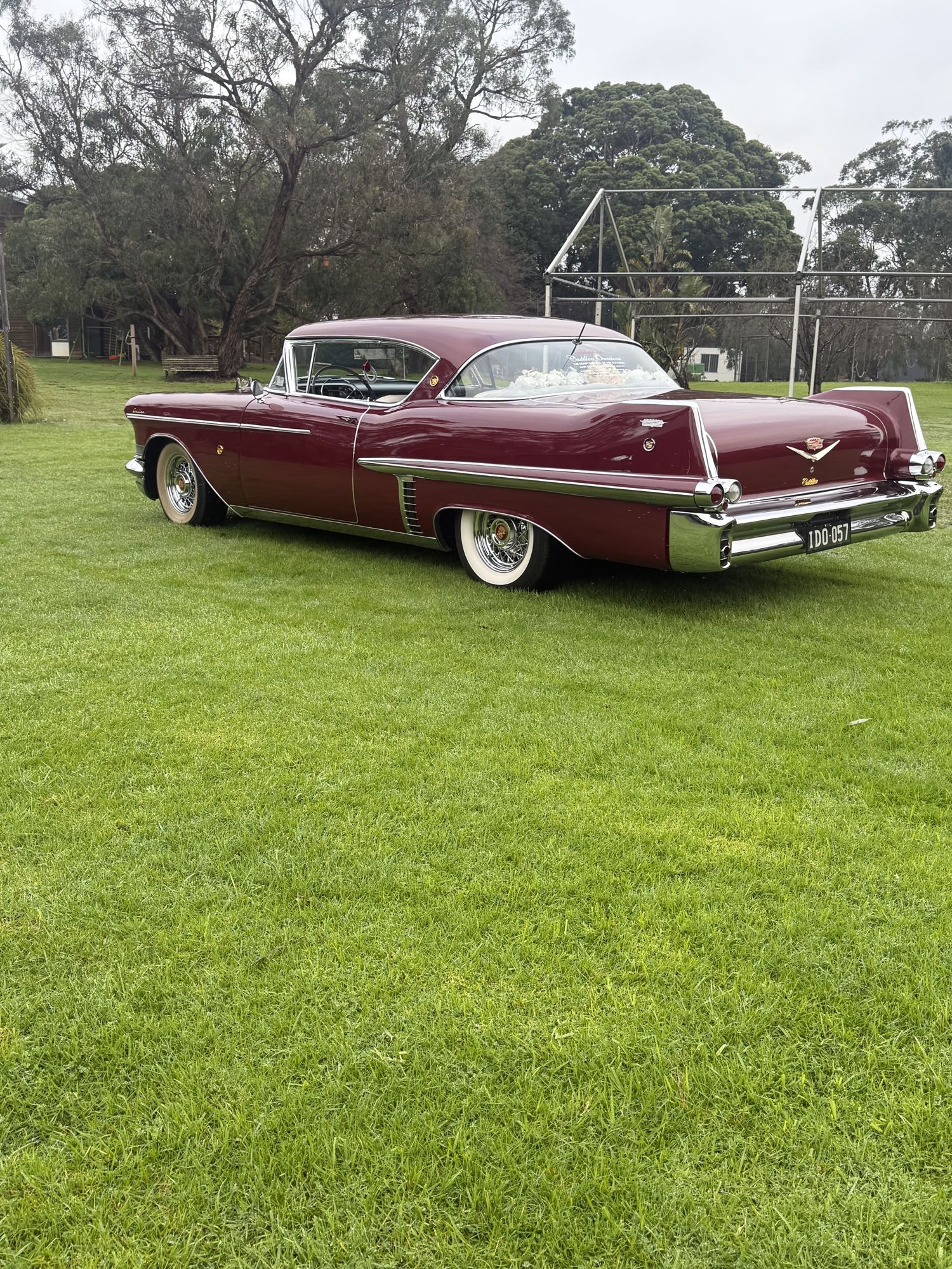 ELLIE Mae, Caddyman's maroon classic Cadillac coupe, parked on a lawn, side view