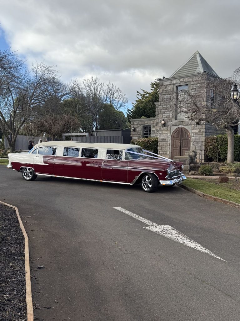 The Prince of Belair, Caddyman's maroon 1955 Chevrolet Bel Air stretch limousine parked outside a stone church